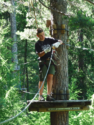 vacanze d'estate in montagna sicurezza al parco avventura durante il percorso sugli alberi